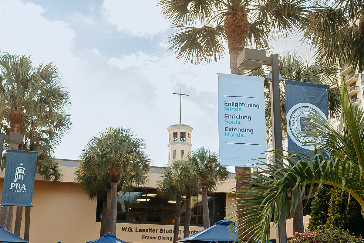 View of the DeSantis Family Chapel framed by palm trees on Palm Beach Atlantic University campus from outside the Lassiter Student Center.