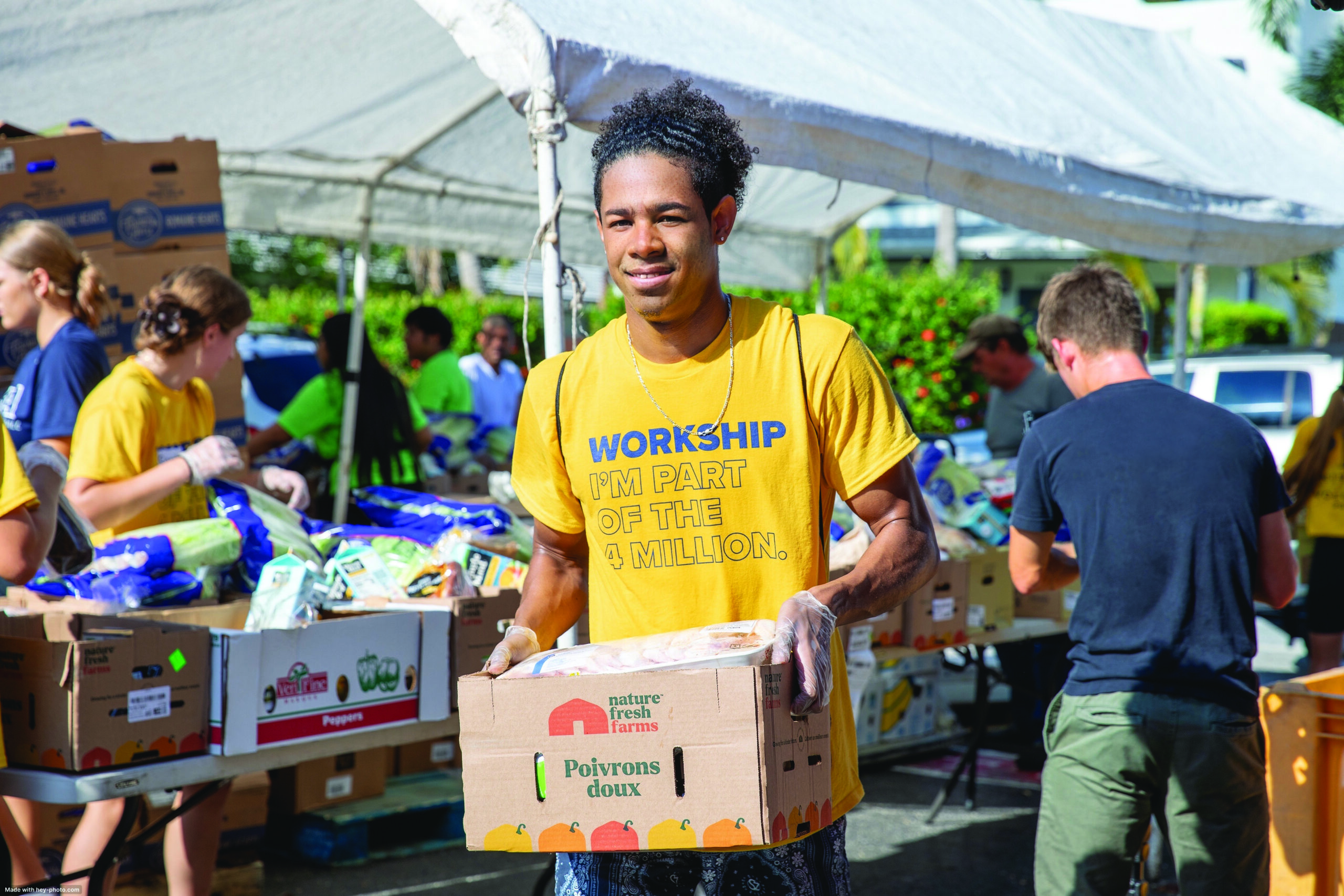 student wearing a workship tshirt carrying a box of food