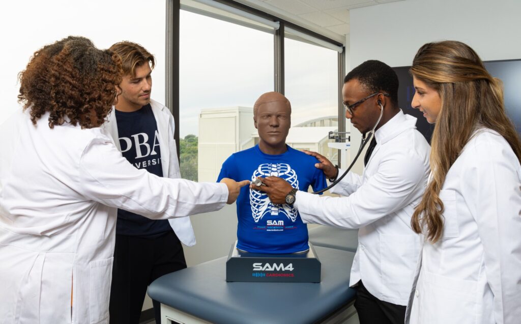 PBA instructor teaches new Physician Associate students how to conduct a medical examination on a bust.