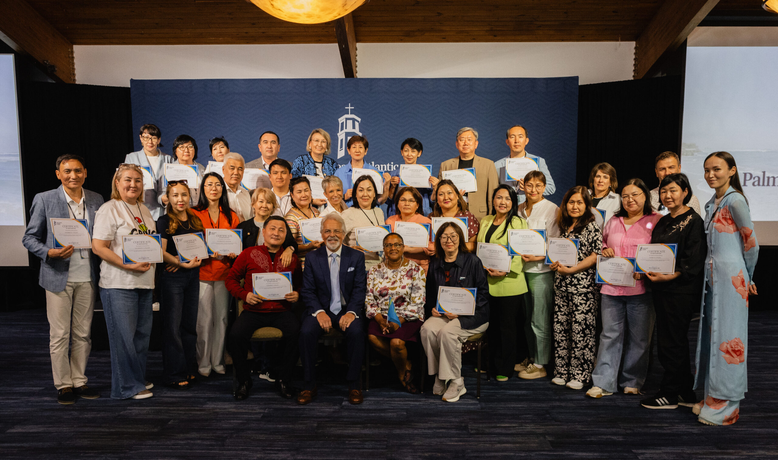 PBA Faculty members, Drs. Frank Marangos and Marcia Bedasse, sit surrounded by the attendees of the Kazakhstan Educators Conference.