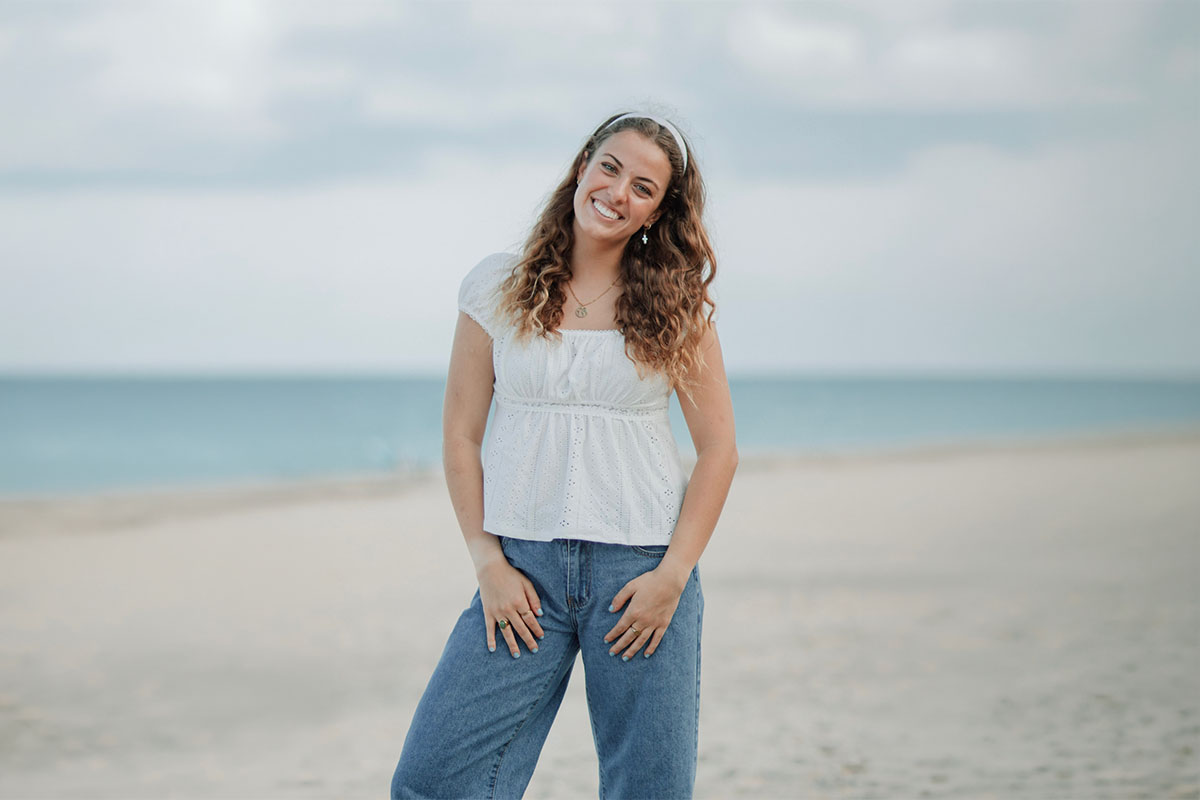 PBA graduate Diana Mankin poses on a beach.