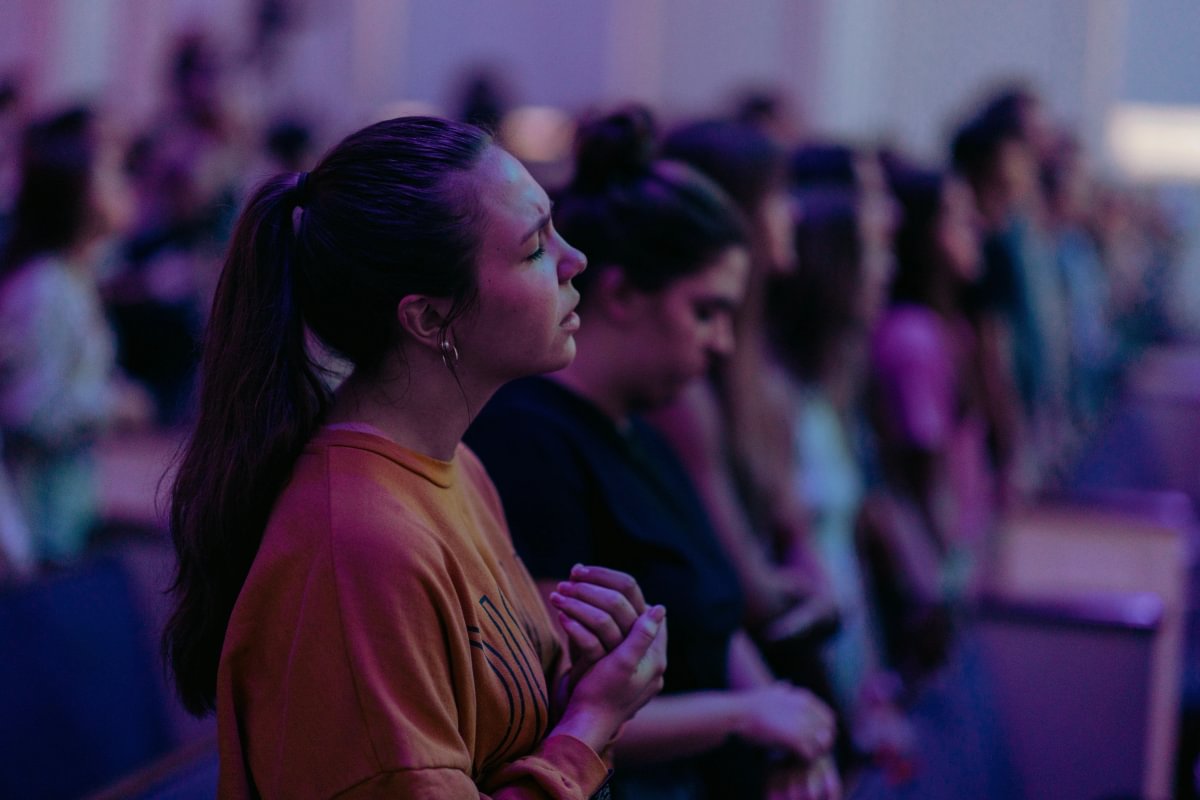 Student praying in a chapel service.