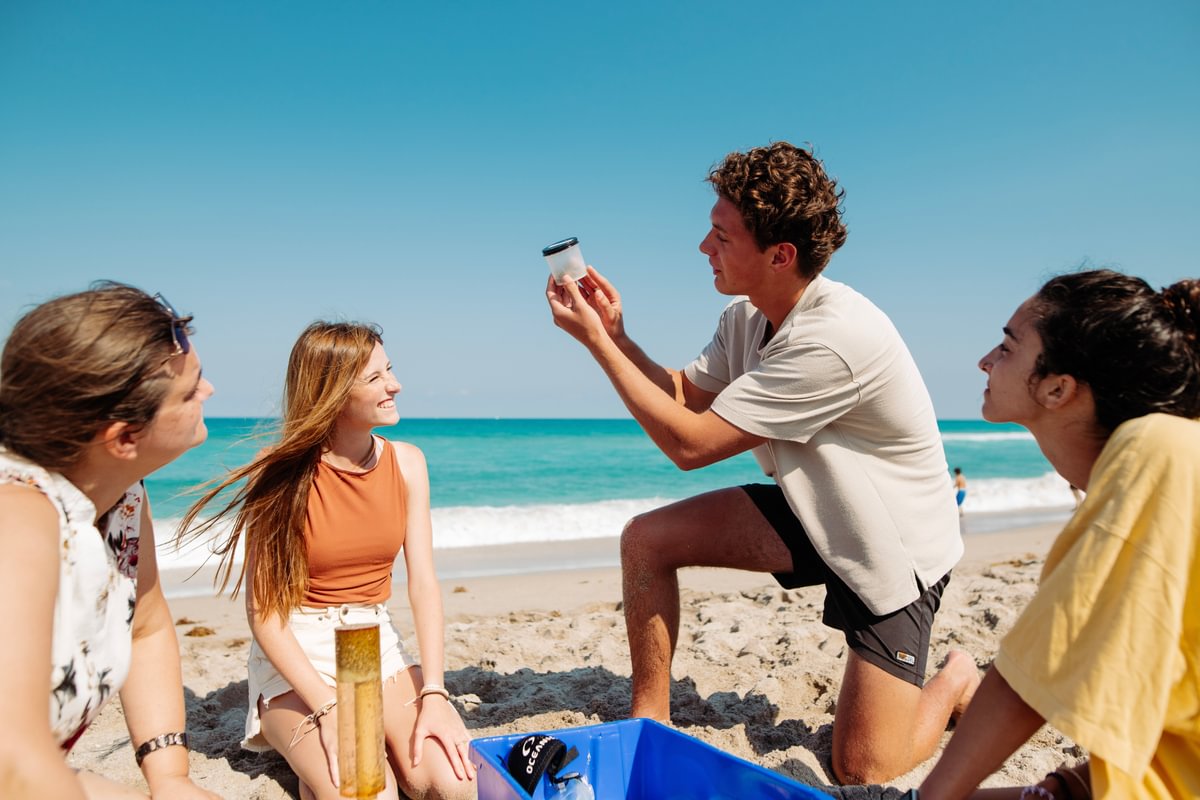 Palm Beach Atlantic University students conduct a marine science experiment on the beach.