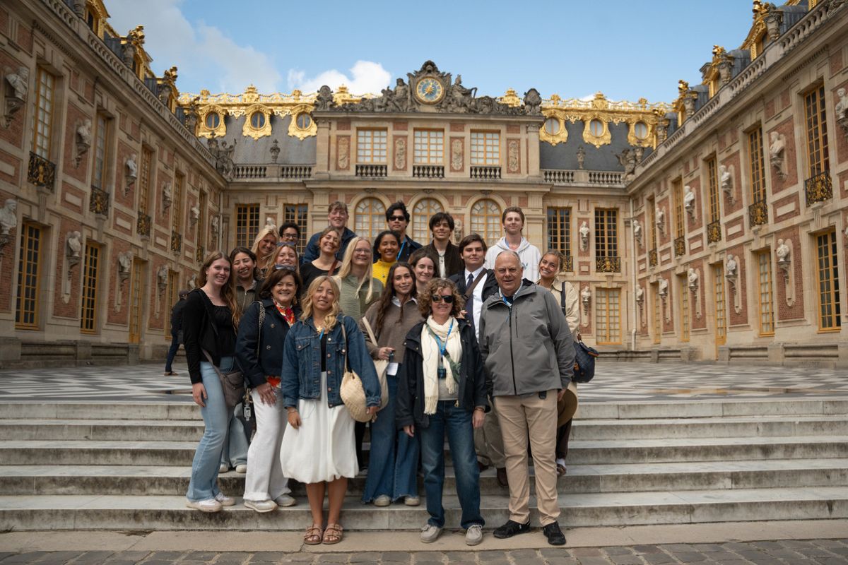 Palm Beach Atlantic University's Frederick M. Supper Honors Program students and professors stand in front of a castle.