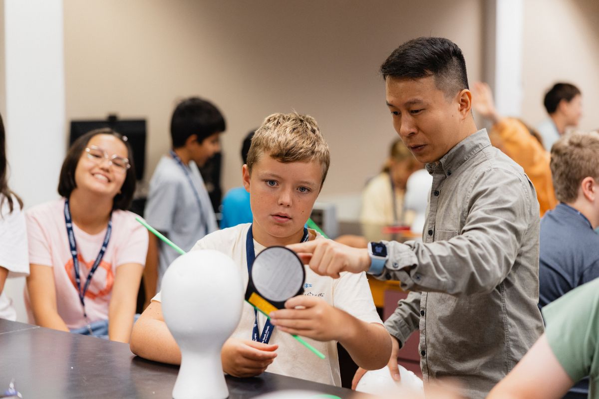 Palm Beach Atlantic University guides student participant in summer science institute forensic experiment.